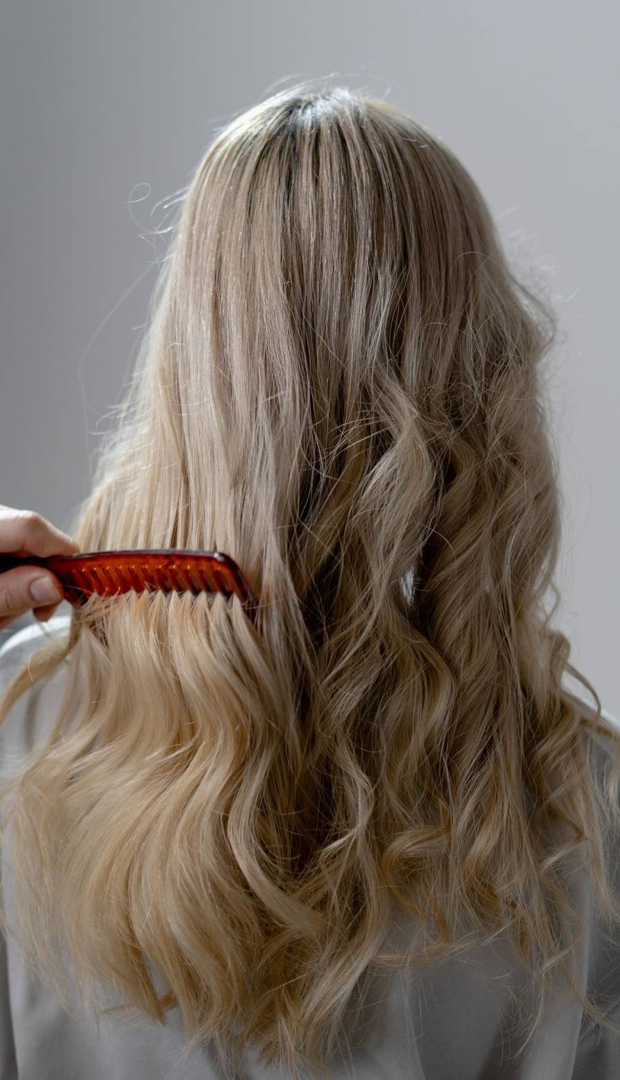 Long blonde curls being combed out after a service